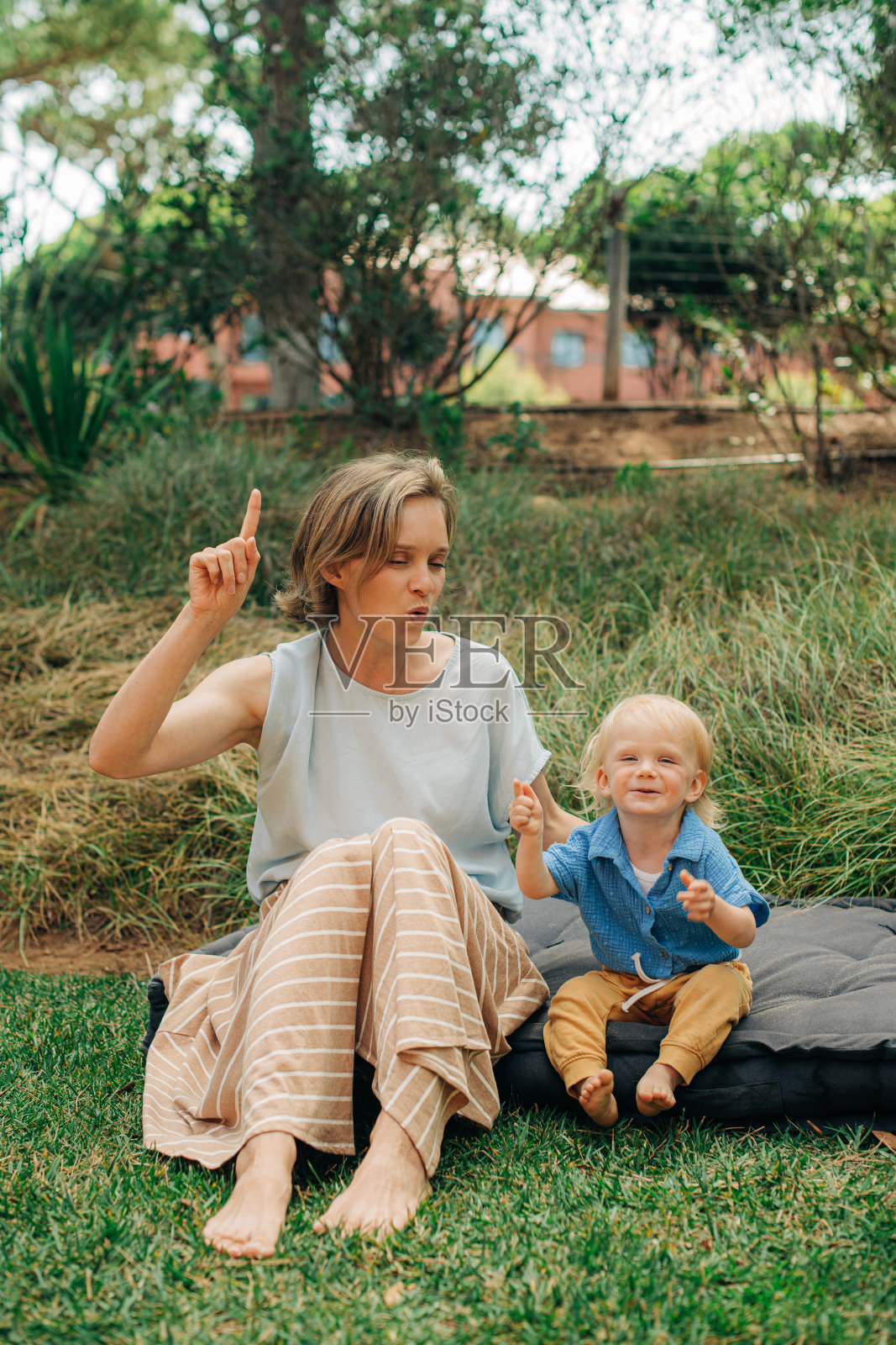 一个带着小孩坐在外面的快乐女人照片摄影图片