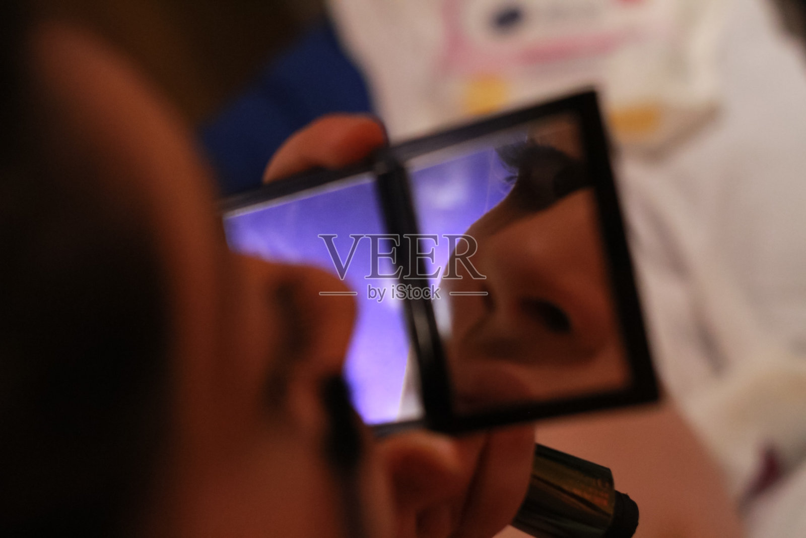 一个女人用手镜化妆的细节照片摄影图片