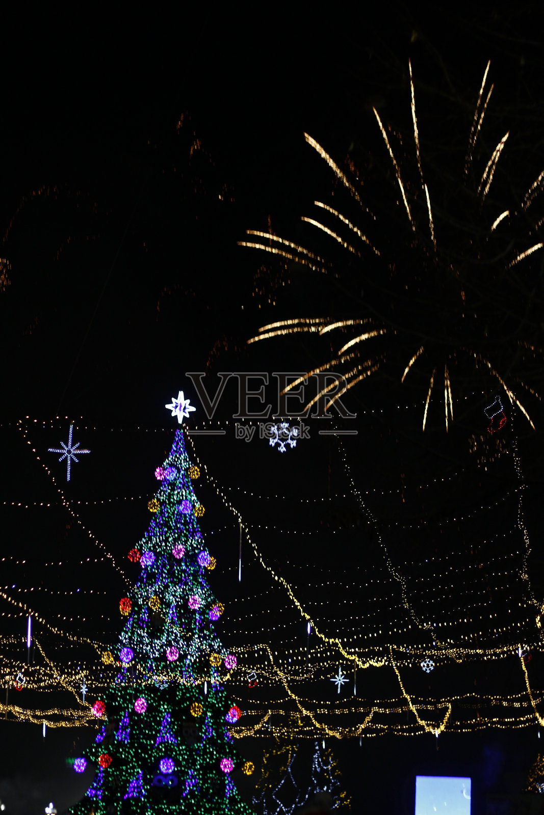 夜行敬礼在城市的圣诞树上，模糊了午夜的背景照片摄影图片