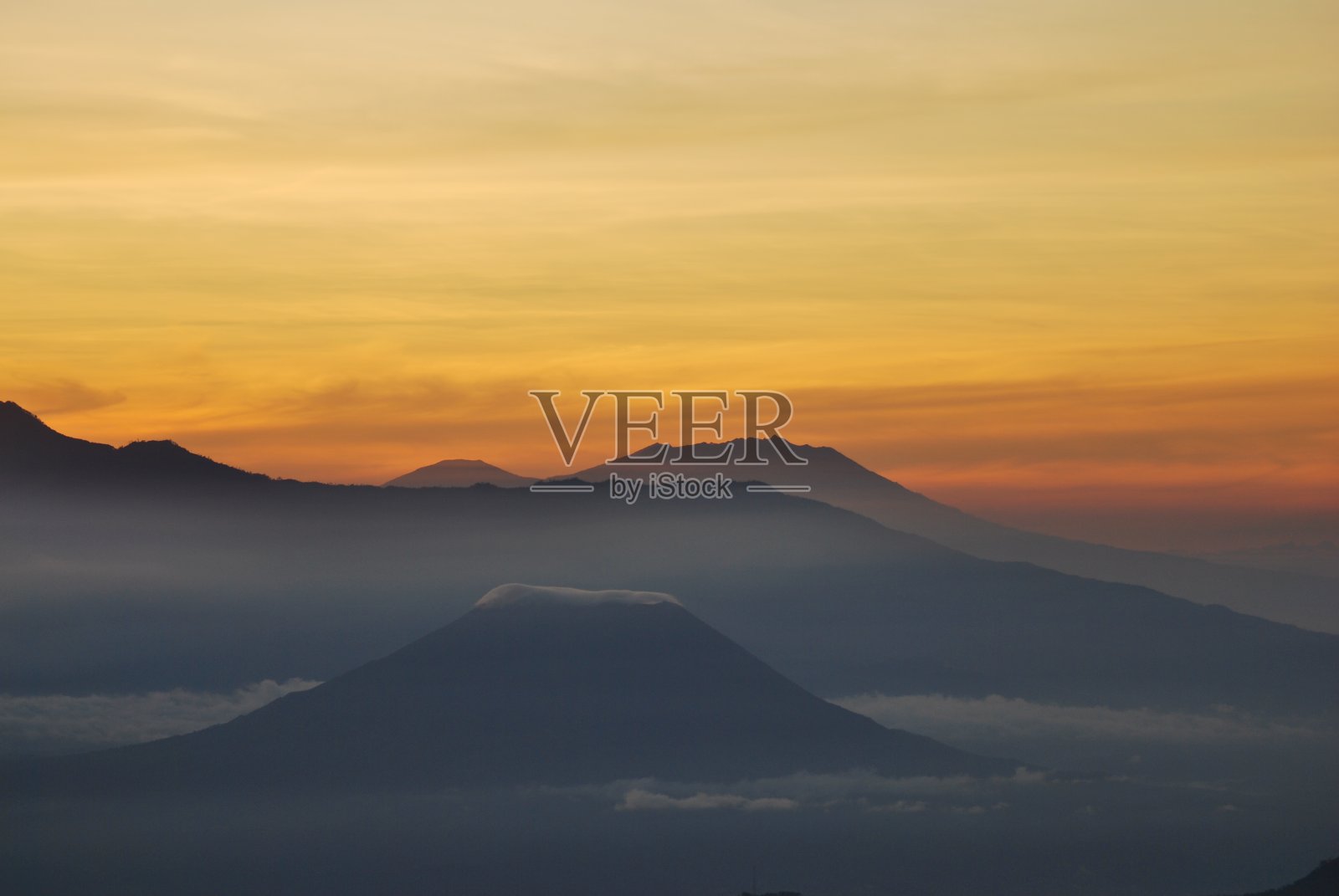 林贾尼山的景观和金光日出日出与雾和薄雾周围的山谷。在印尼的布罗莫腾格里塞默鲁国家公园的布罗莫山上的景色照片摄影图片