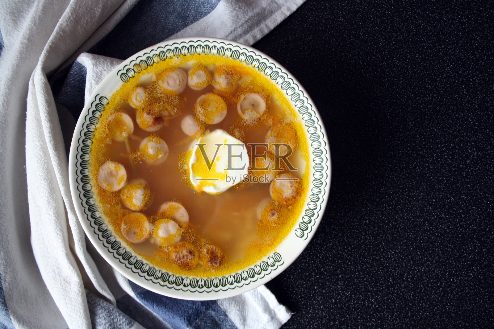 土豆香肠汤。快盘。黑色背景。照片摄影图片
