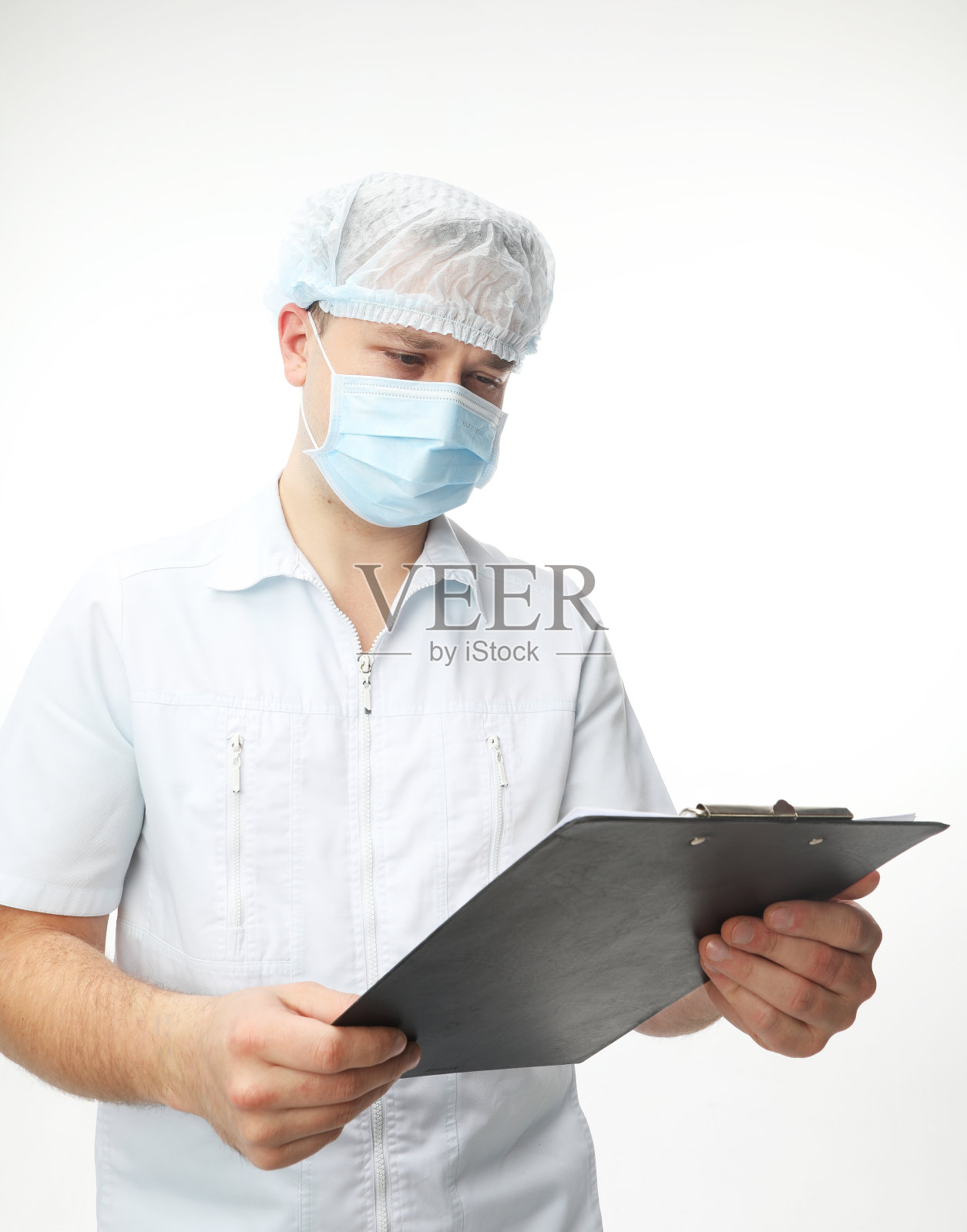 戴口罩的男医生记录病人的病史。医学的概念照片摄影图片