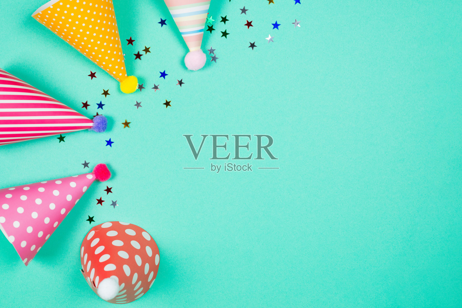 蓝色背景上的彩色生日帽。前视图。照片摄影图片