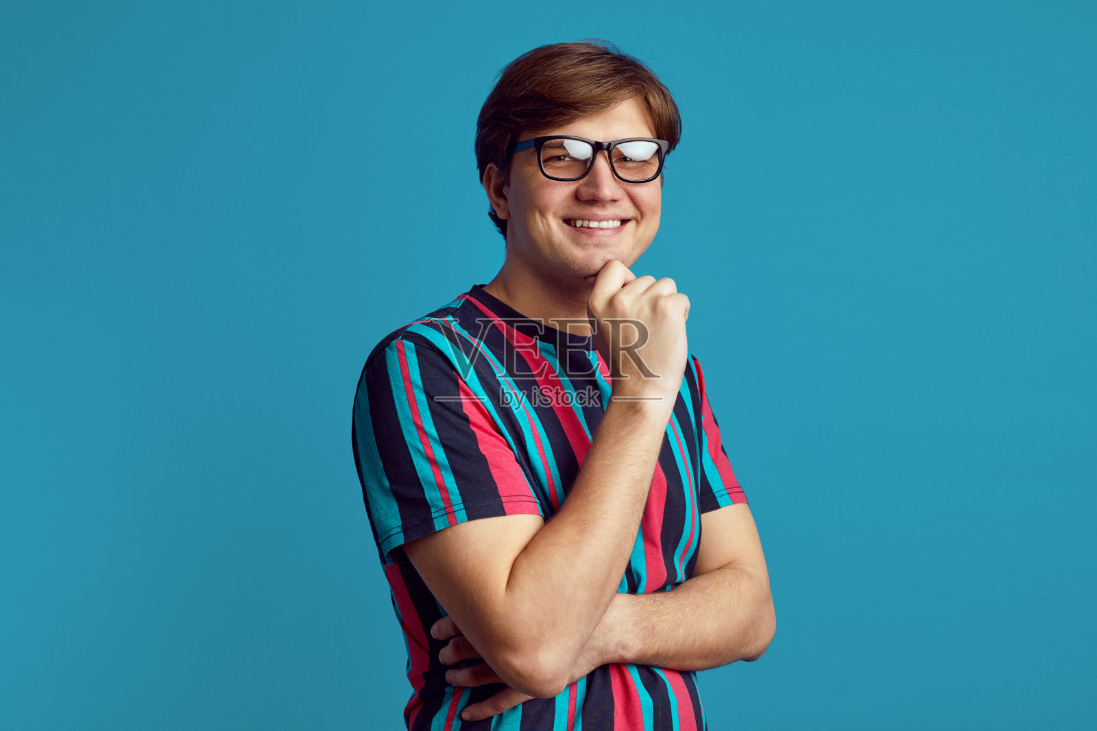 开朗的人有沉思的开朗的表情，手放在下巴下照片摄影图片