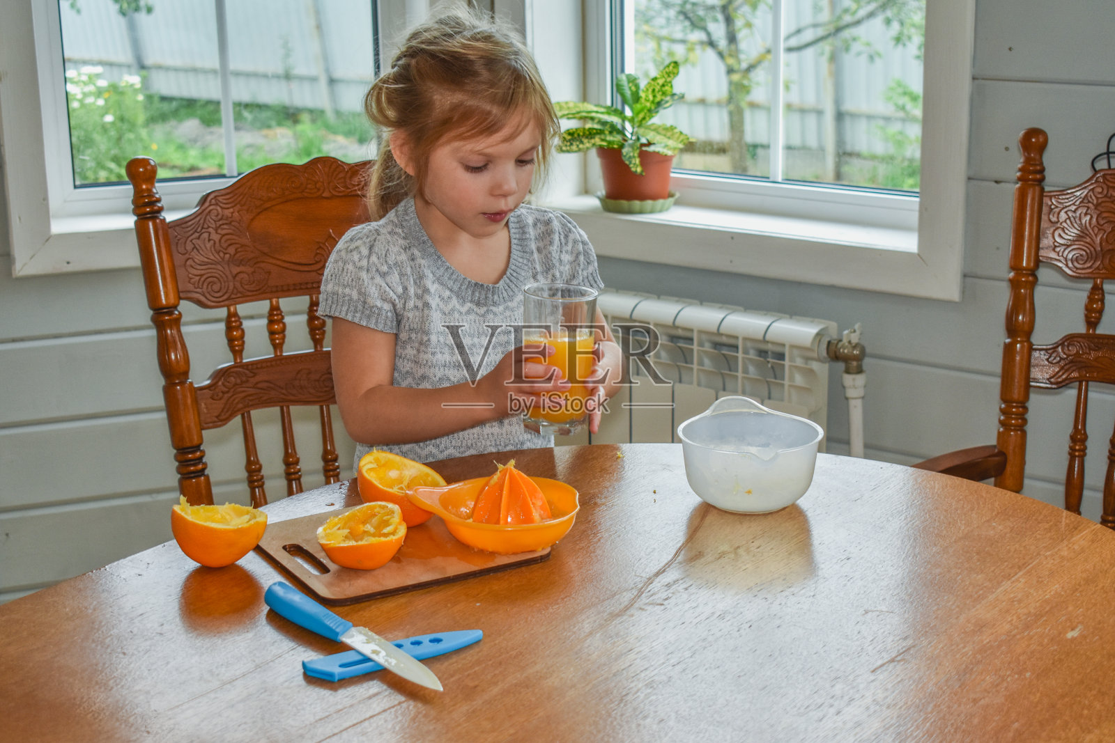 小女孩在厨房里切橘子汁照片摄影图片