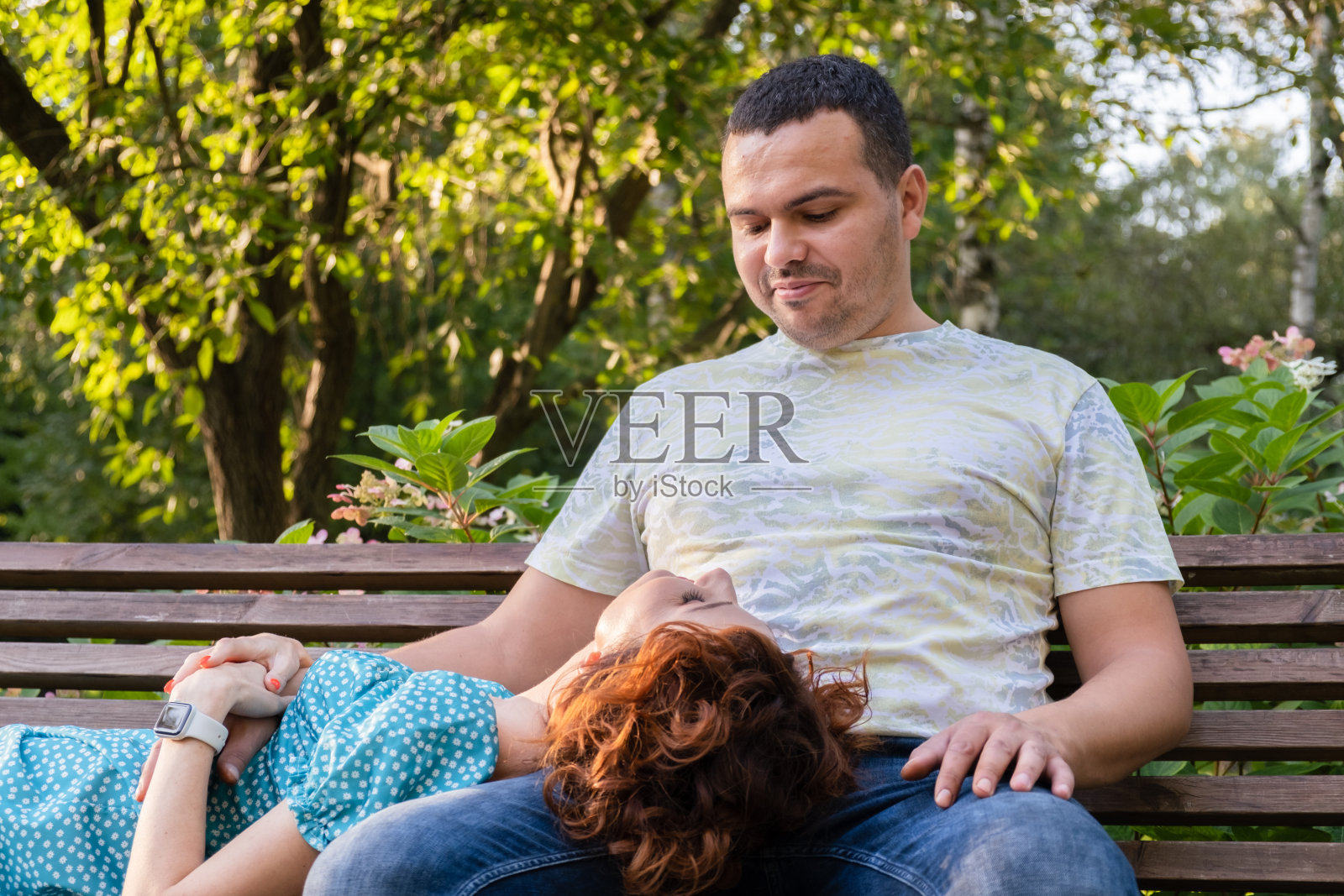 在公园长椅上充满爱意地互相注视的情侣照片摄影图片