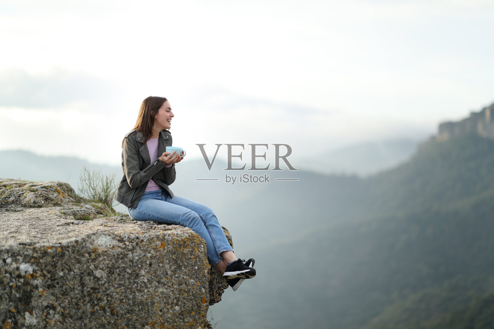 一个在悬崖边喝咖啡的快乐女人照片摄影图片