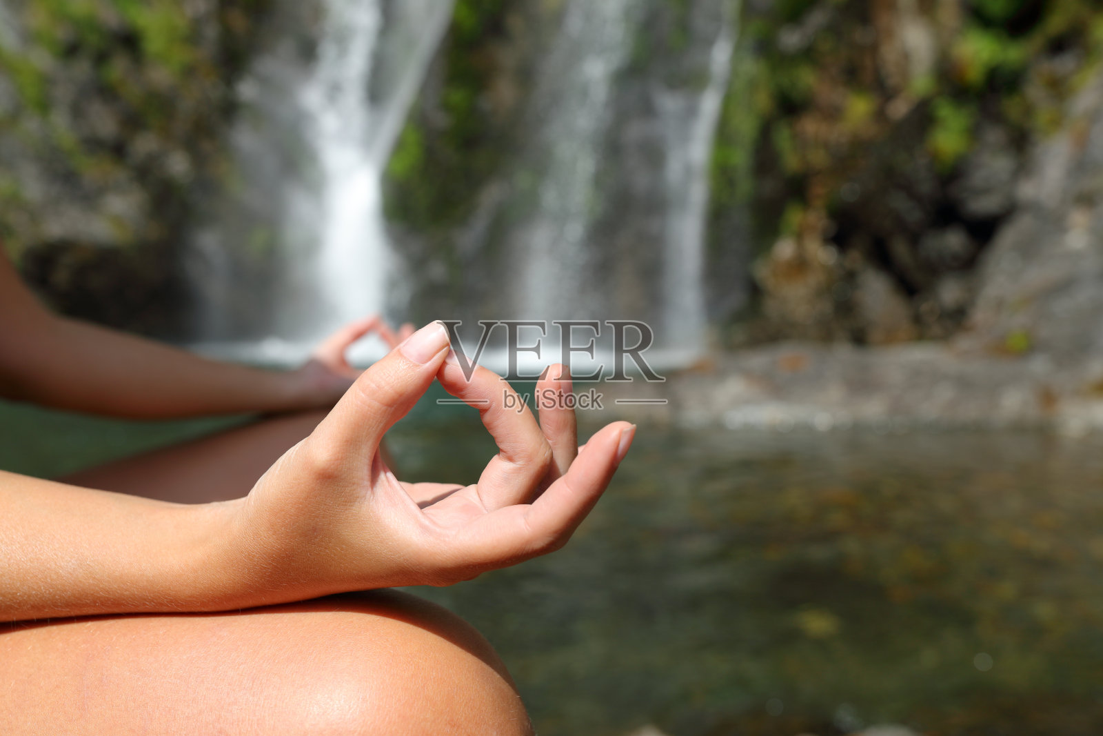 女人在瀑布里做瑜伽照片摄影图片