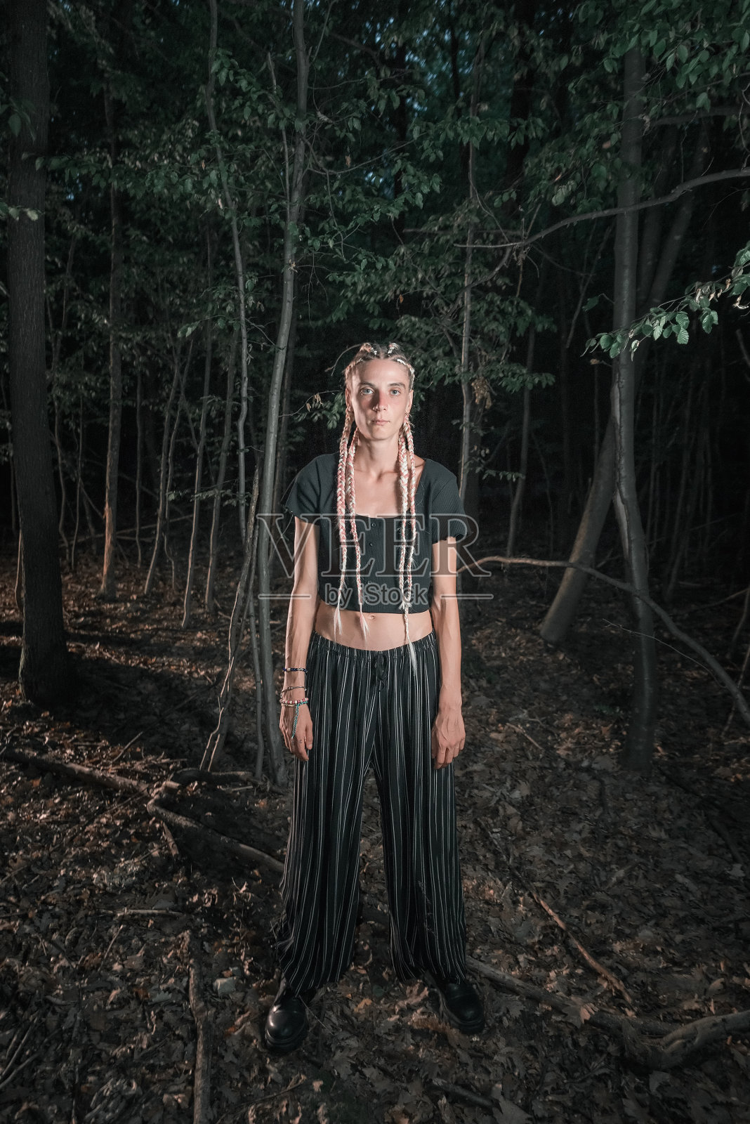 年轻的哥特女孩独自站在黑暗的森林里照片摄影图片