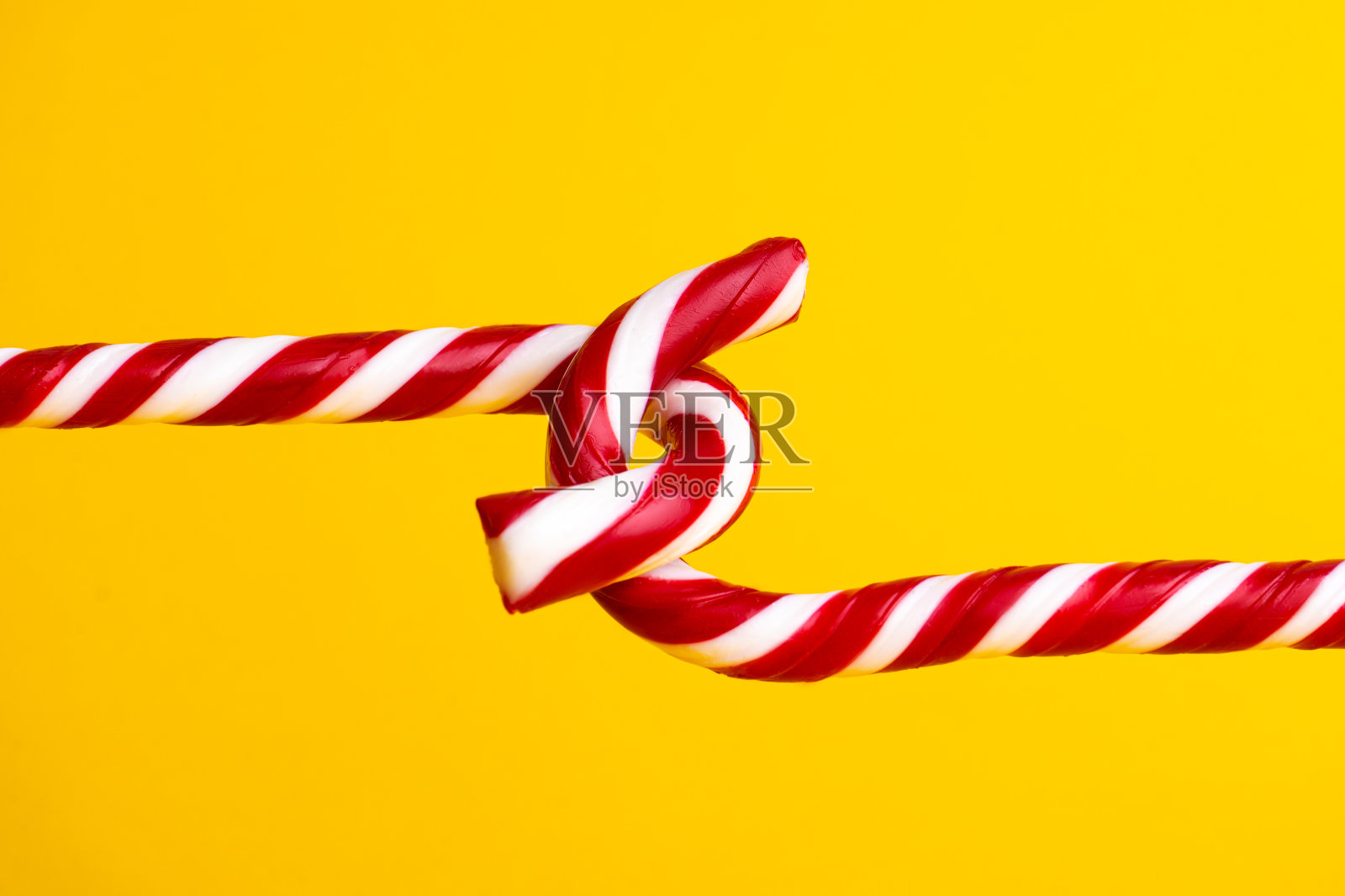 黄色背景上的棒棒糖，圣诞糖果照片摄影图片