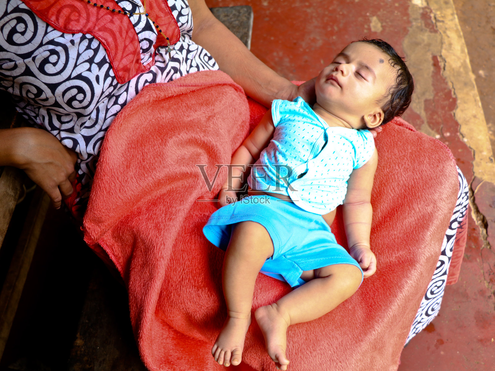 可爱的男孩趴在妈妈的膝上照片摄影图片