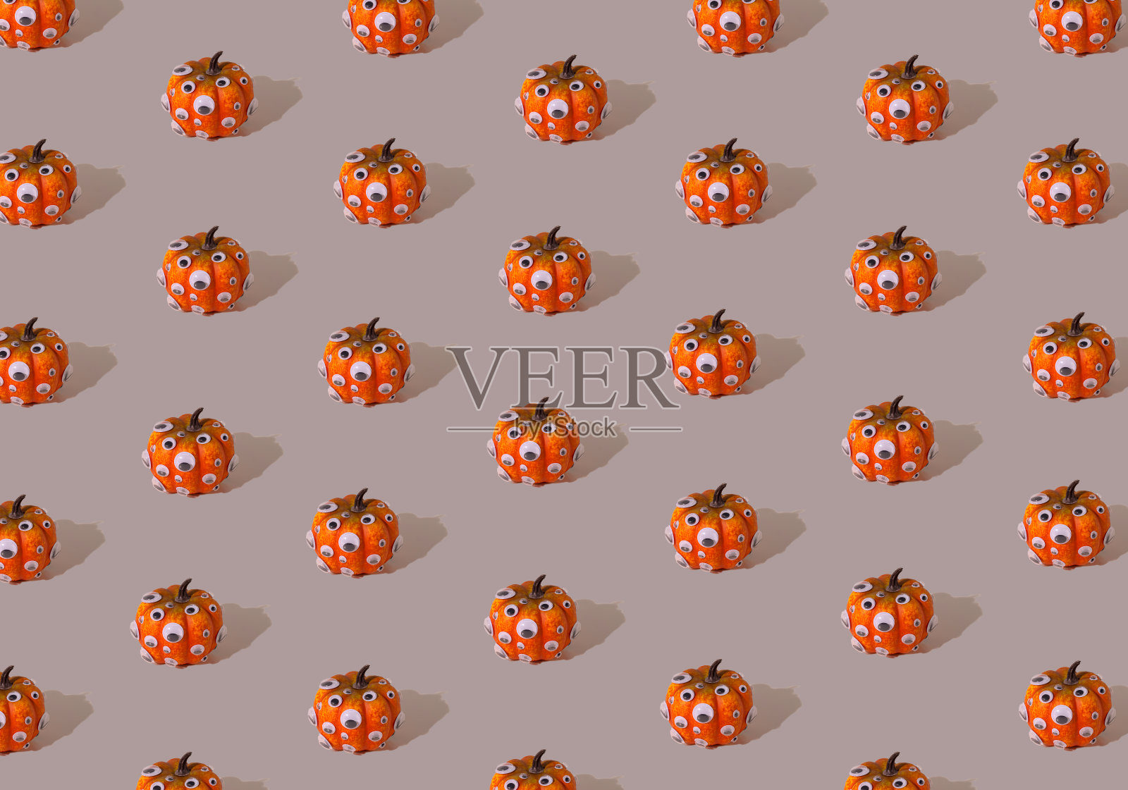 橙色南瓜图案与眼睛的灰色背景，万圣节的概念插画图片素材