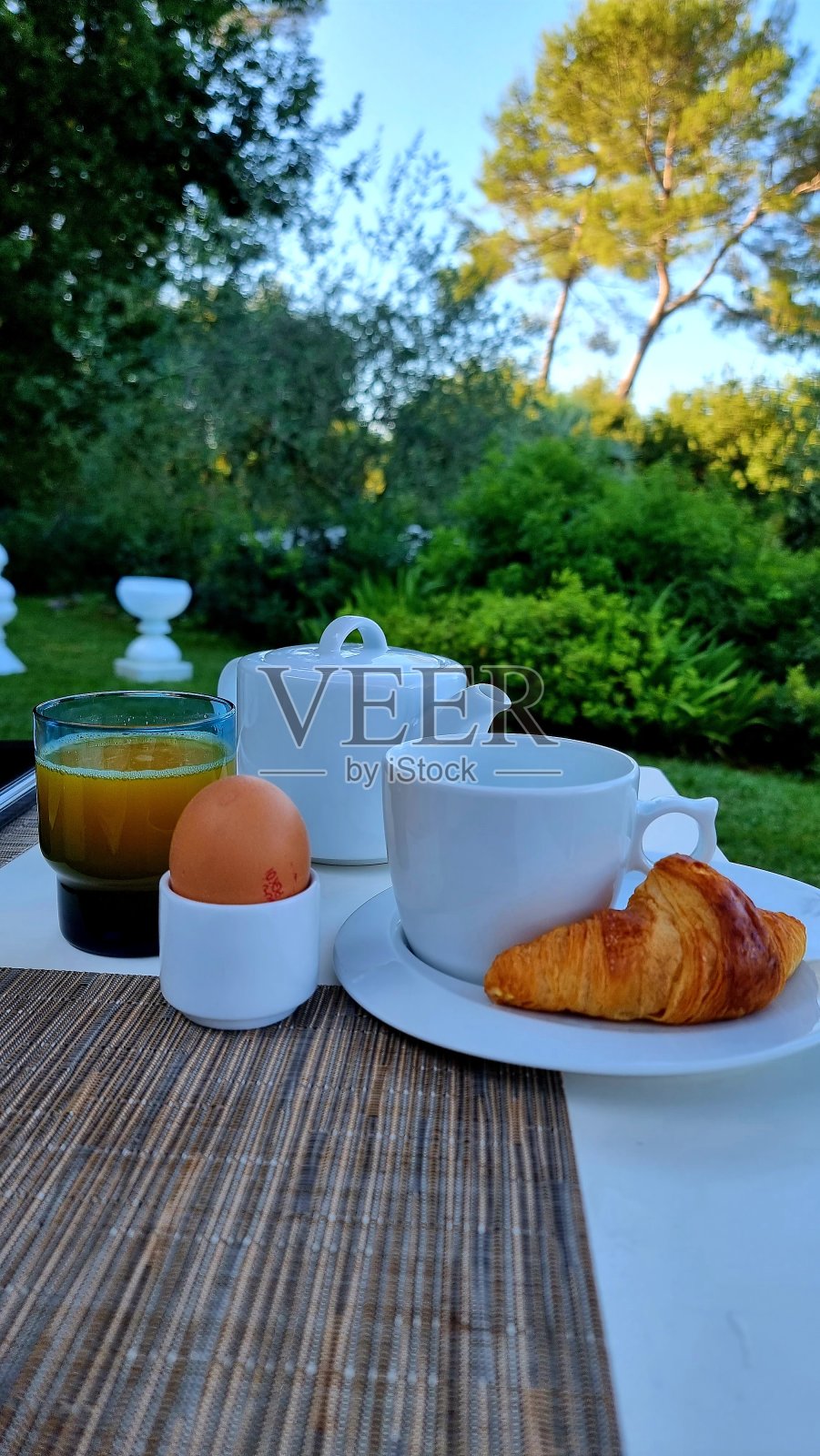 早餐加一杯咖啡，鲜橙。在大自然中，花园里的架子上有一个煮鸡蛋，桌子上有一个十字叉照片摄影图片