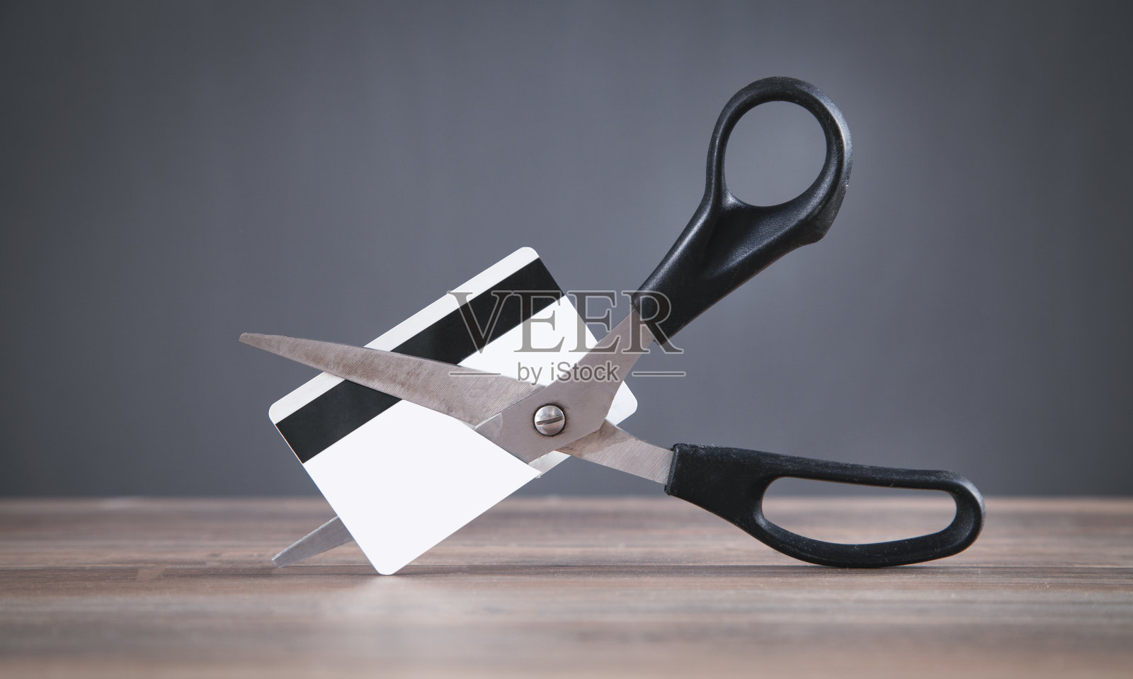 黑色剪刀在剪信用卡。照片摄影图片