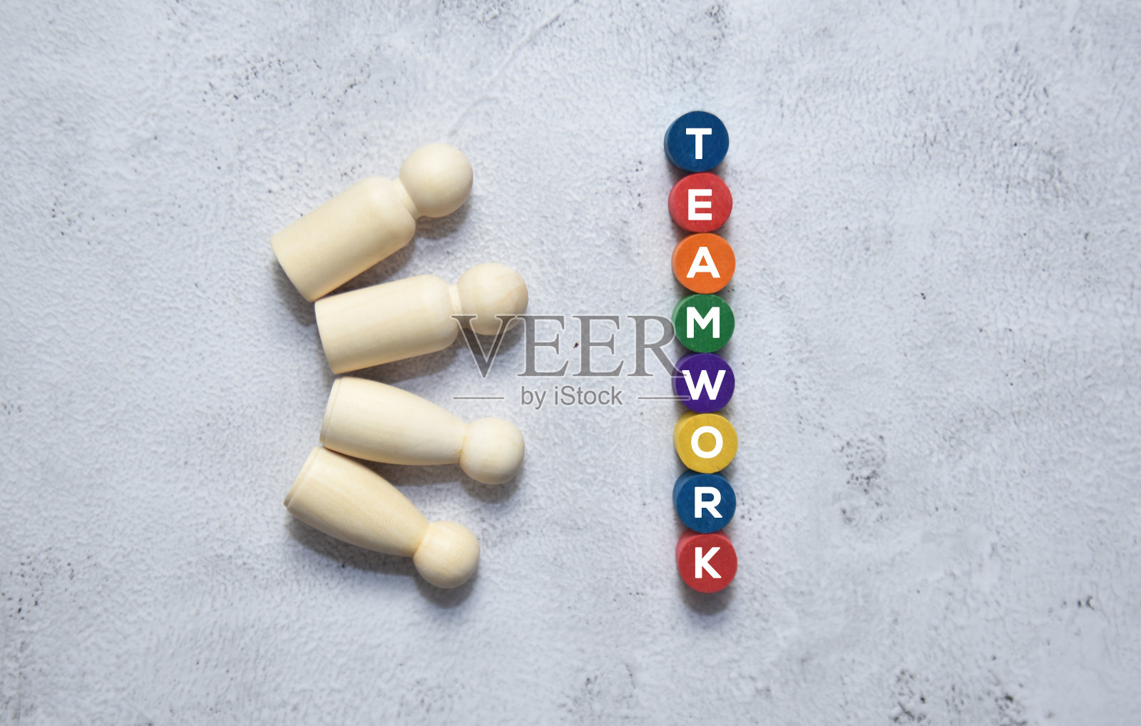 一组木制娃娃与团队合作的文字在圆形彩色木块。照片摄影图片