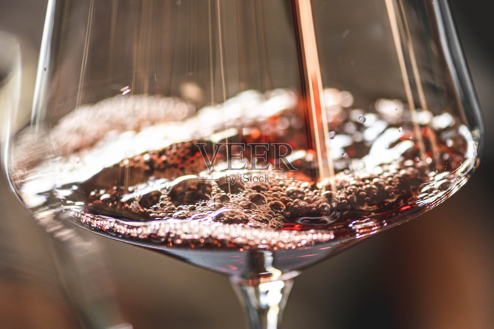 将红酒倒入有气泡的酒杯中照片摄影图片