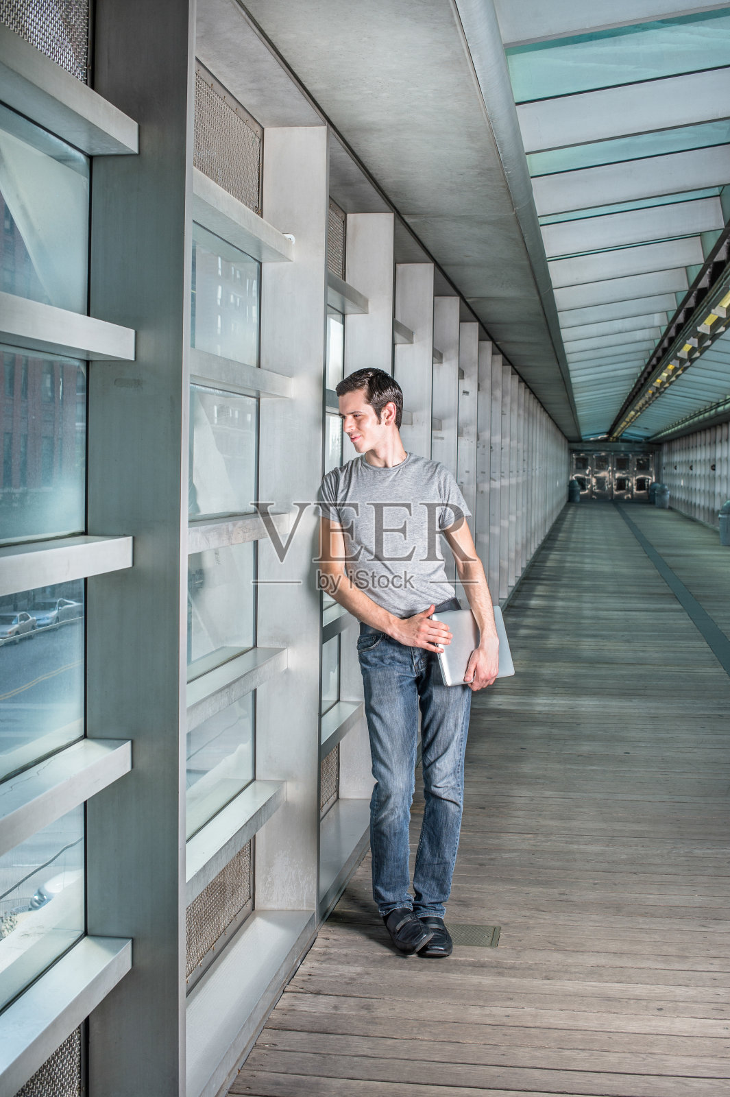 一个年轻人站在纽约市的人行道上，环顾四周照片摄影图片