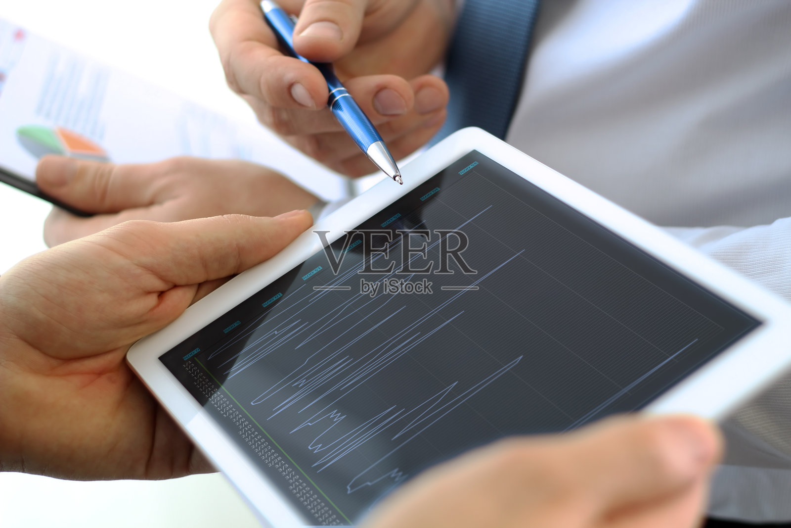 业务同事用平板电脑讨论和分析股票行情图表、股票行情图表照片摄影图片