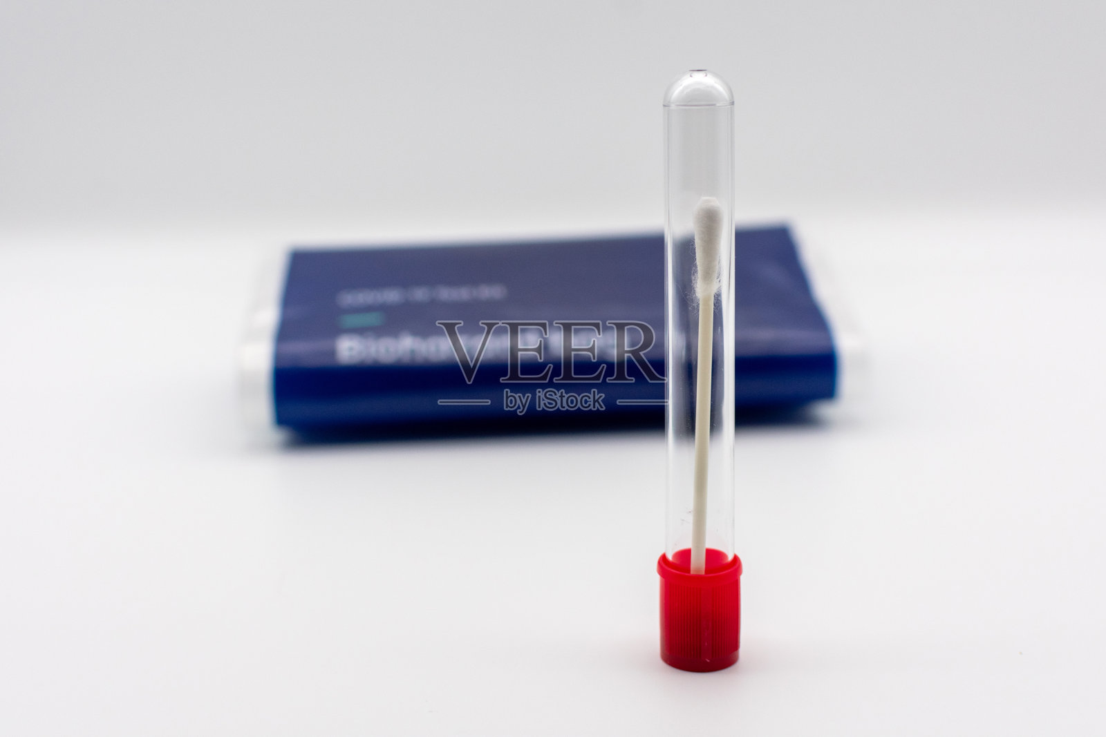 带棉签的标本采集管。生物危害袋背景模糊。照片摄影图片