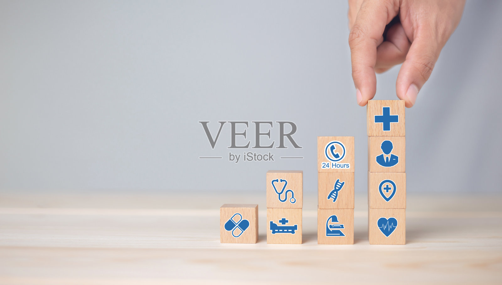 手安排木块堆叠与图标保健医疗，健康保险-概念。照片摄影图片