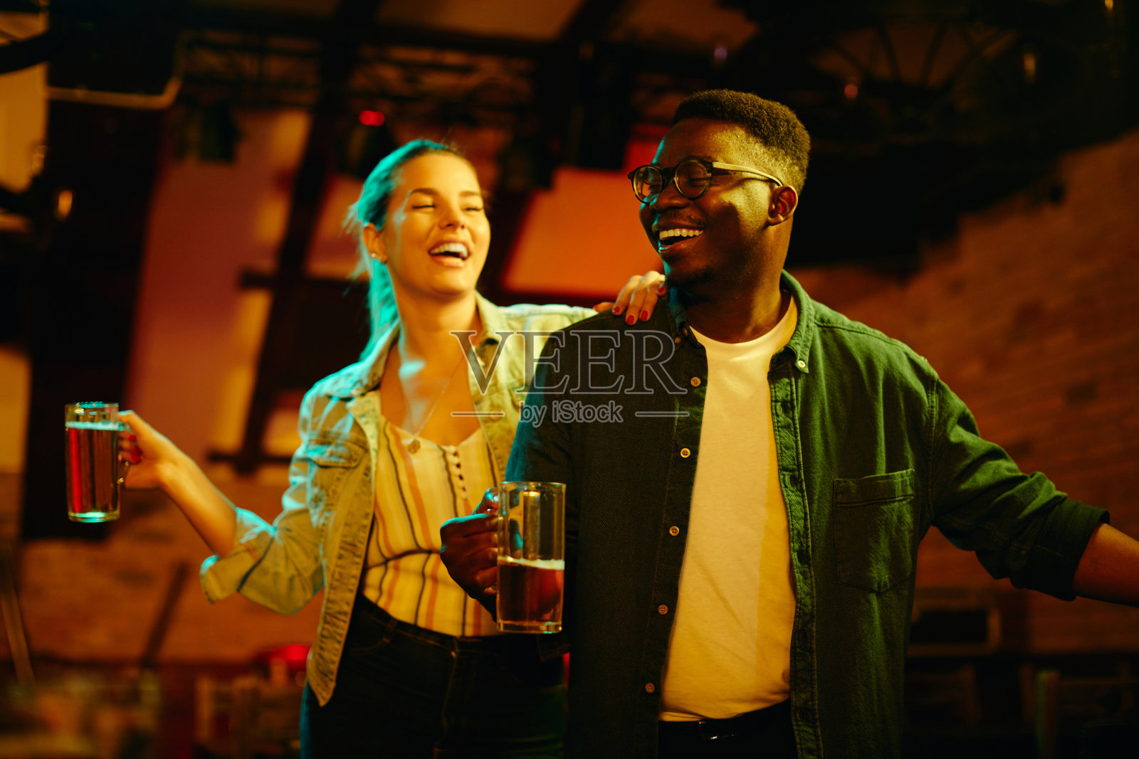 年轻幸福的夫妇在酒吧跳舞，晚上玩得很开心。照片摄影图片