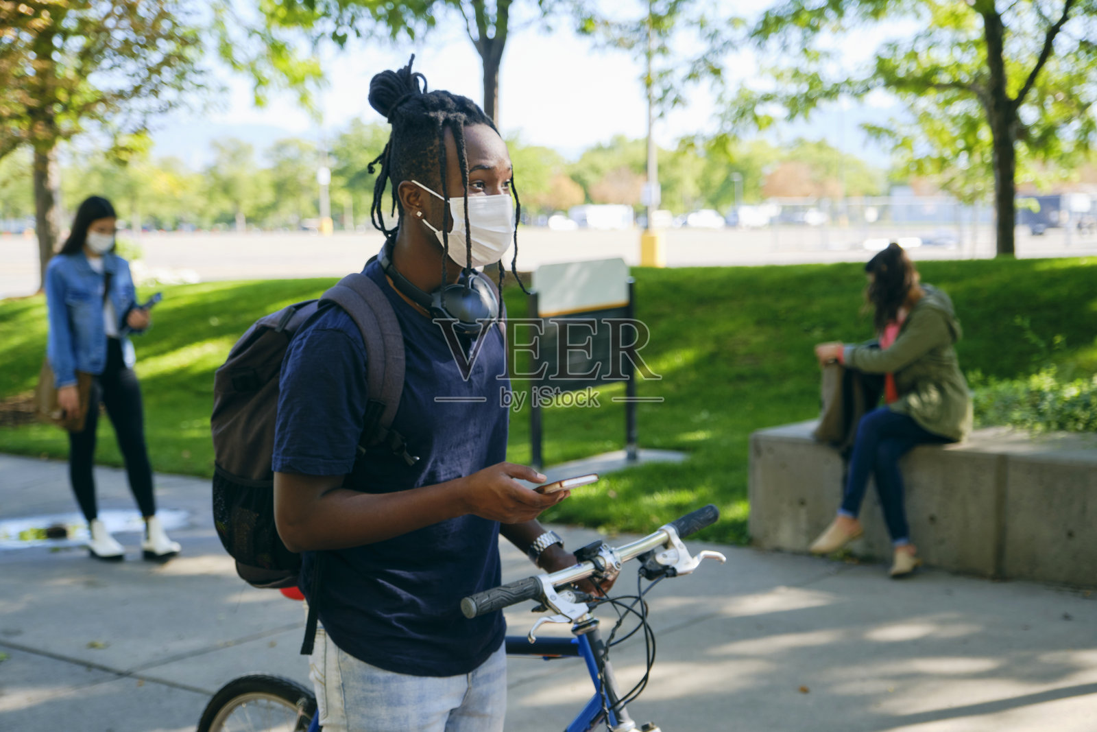 在校园内戴口罩的大学生群体。照片摄影图片