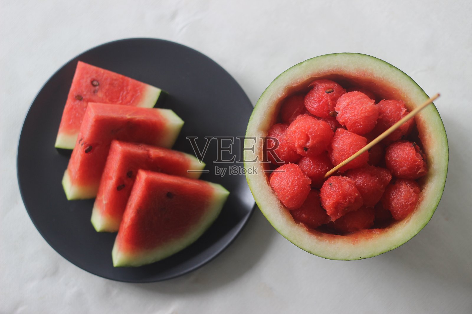 新鲜的西瓜片。在夏天的炎热中保持身体凉爽是很好的。与西瓜勺和果汁一起拍摄照片摄影图片