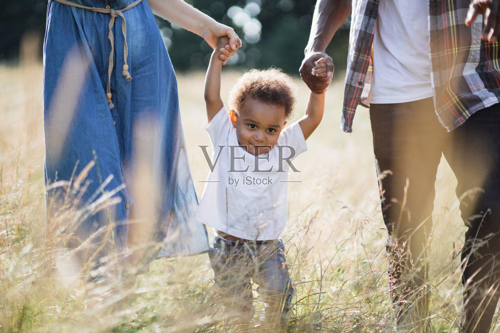 白种女人和非洲男人带着儿子在户外散步照片摄影图片