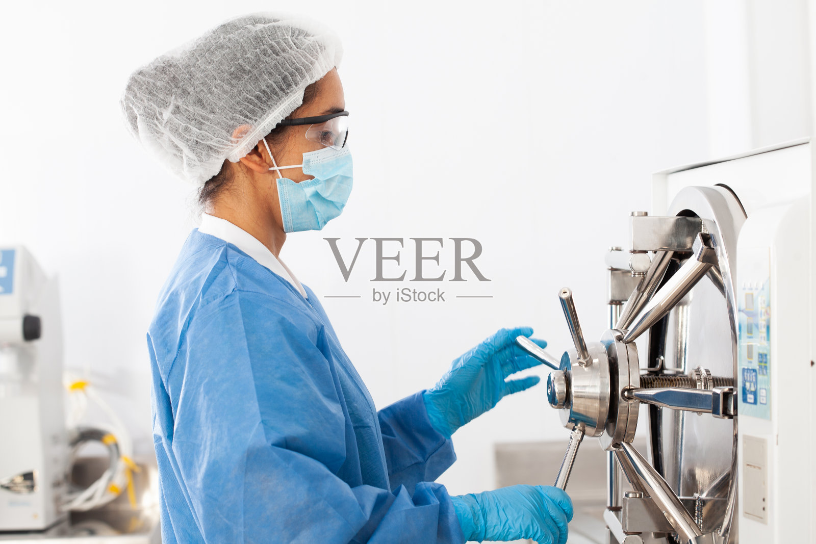 年轻的女科学家在高压釜中灭菌实验室材料照片摄影图片