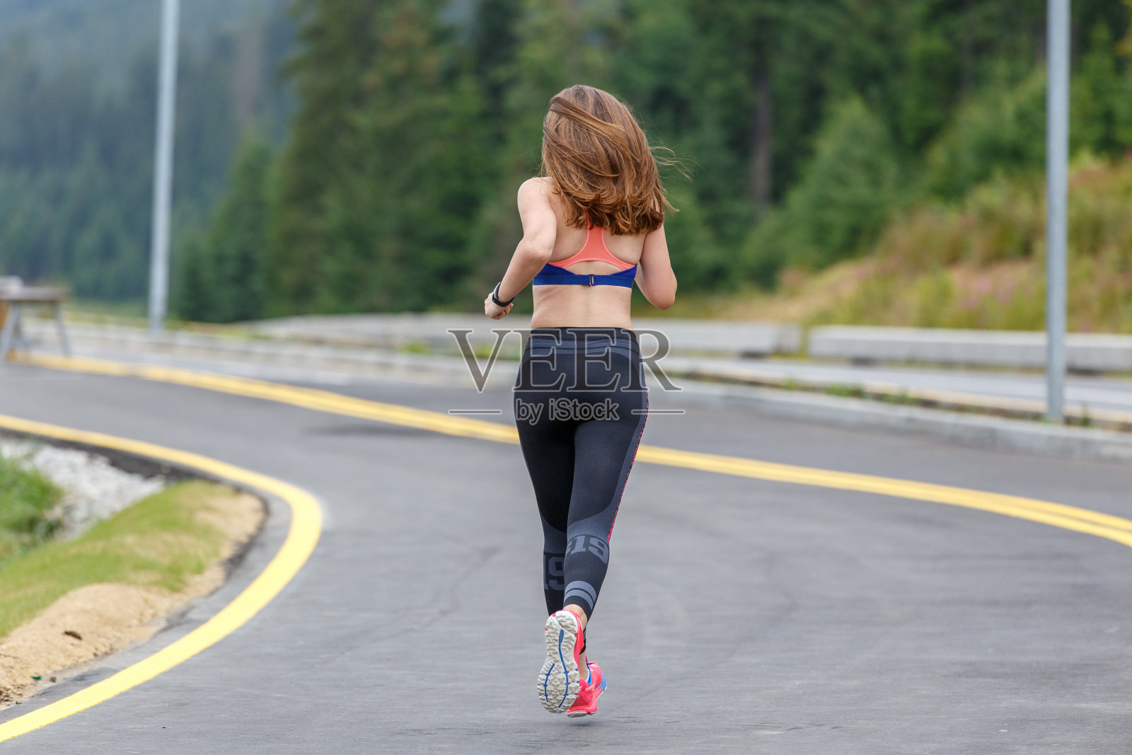 年轻苗条的女人早上在路上跑步照片摄影图片