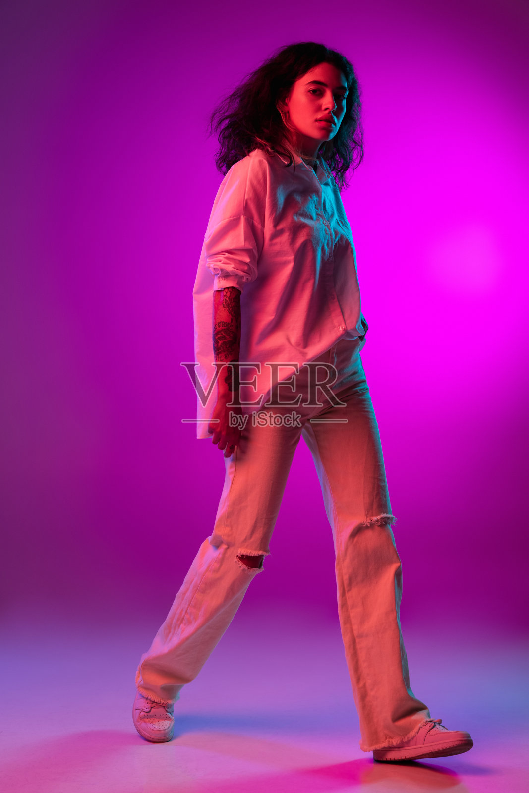 拉丁美丽快乐的女孩的肖像孤立在紫色，紫丁香色工作室背景在霓虹灯。人类情感的概念，面部表情照片摄影图片