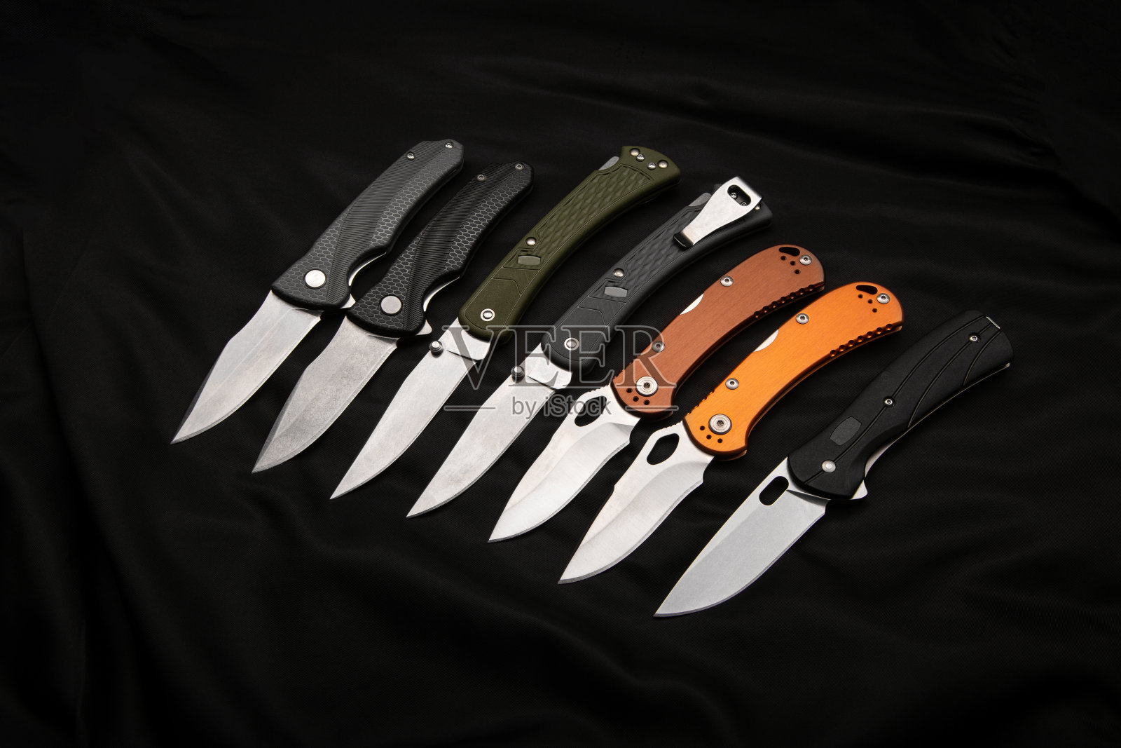 各种折叠口袋刀在黑暗的背景。一个多功能的口袋工具和自卫工具。照片摄影图片