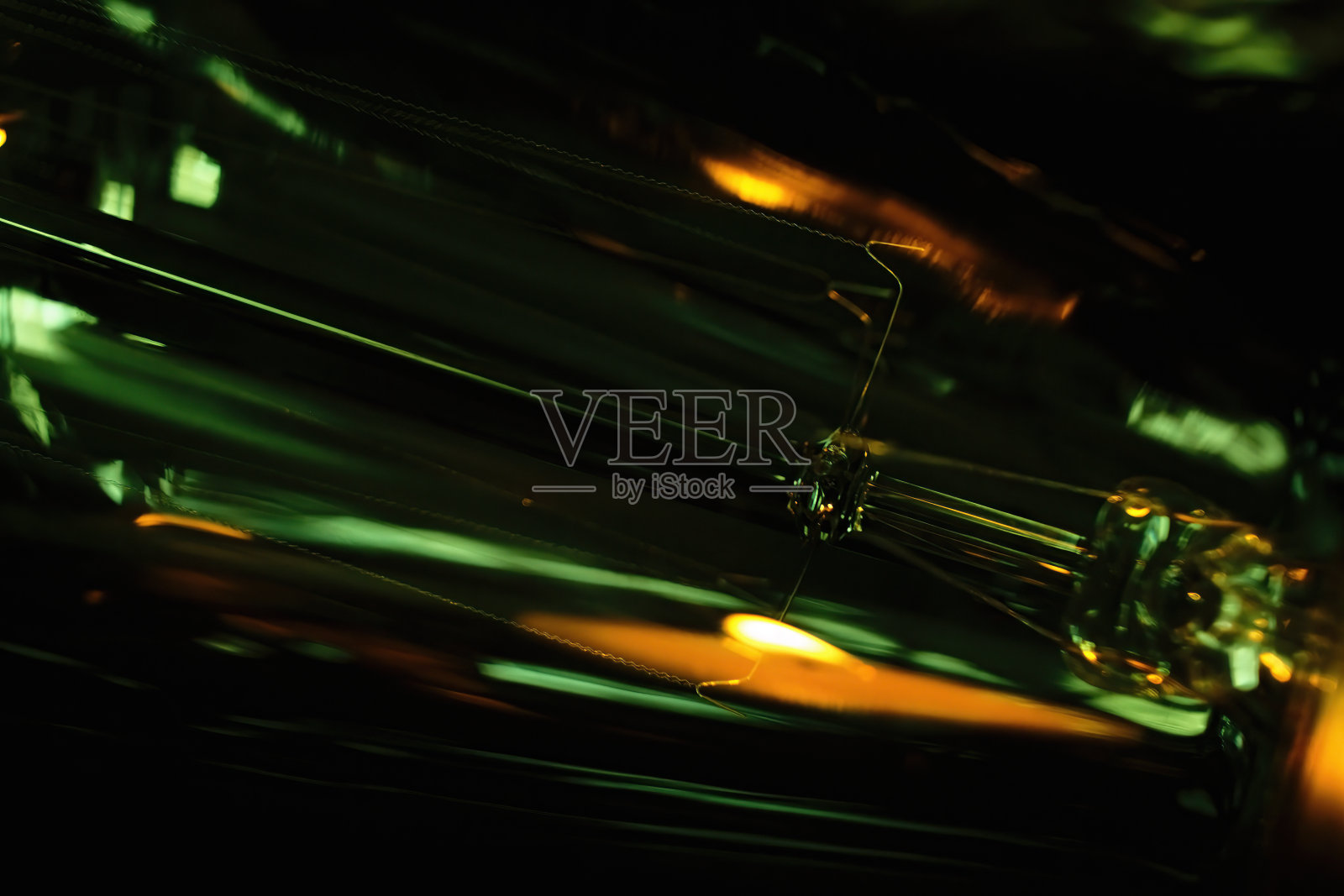 在抽象的宏观视图中带有暖色橙和绿色高光的复古灯泡照片摄影图片