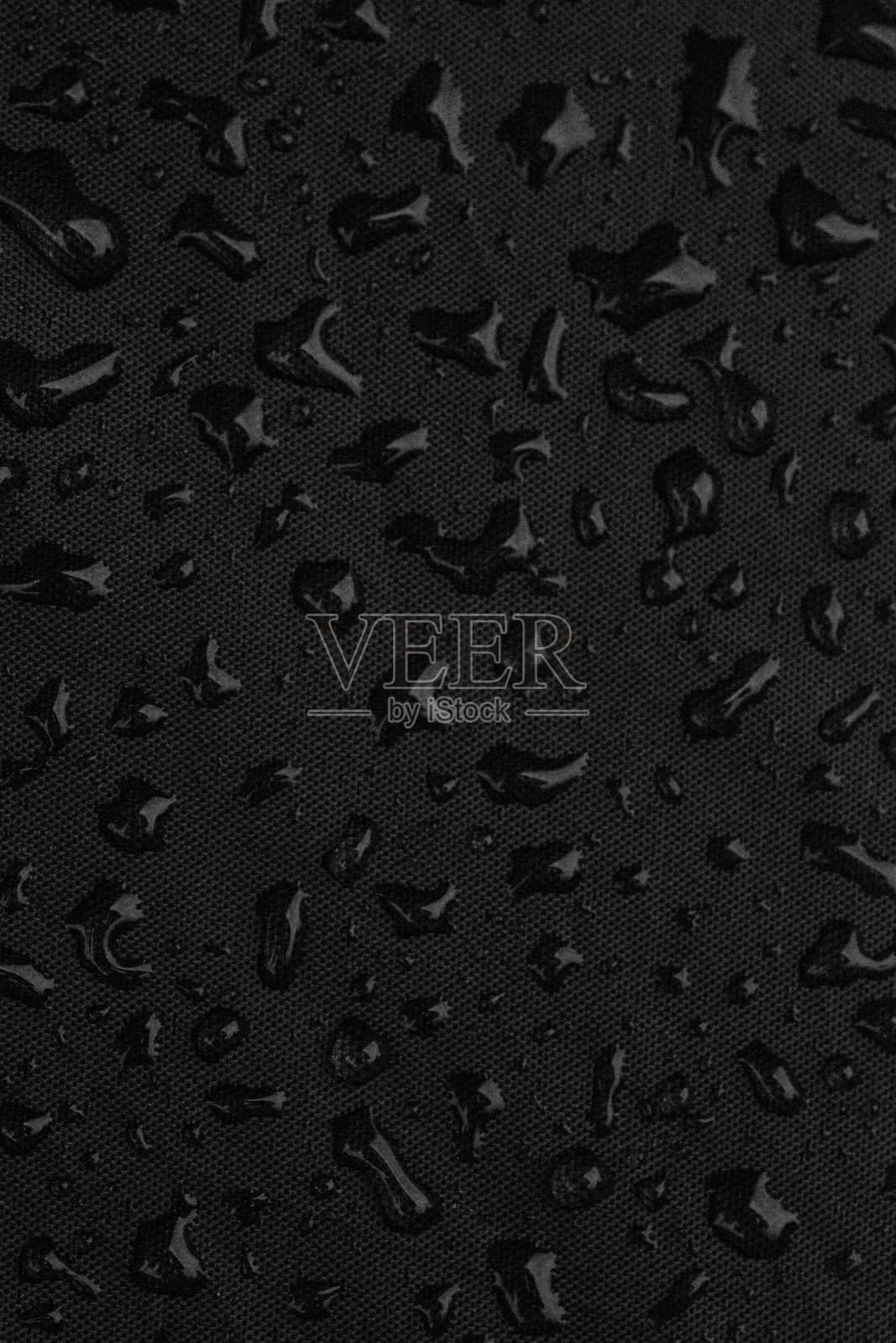 黑色背景上的雨滴的特写，宏观照片摄影图片