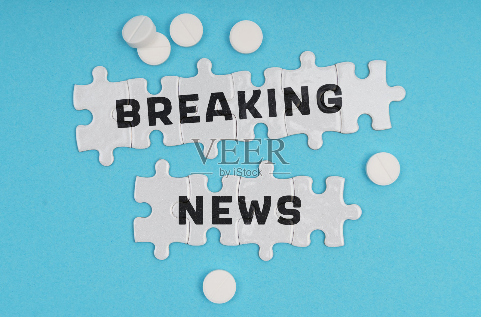 在一个蓝色背景的药丸和谜语的题字-突发新闻照片摄影图片