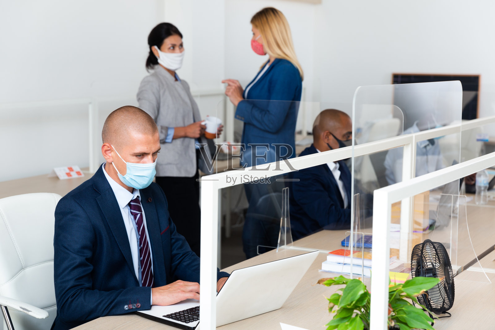 白人男性经理在流行病期间在白色办公室照片摄影图片