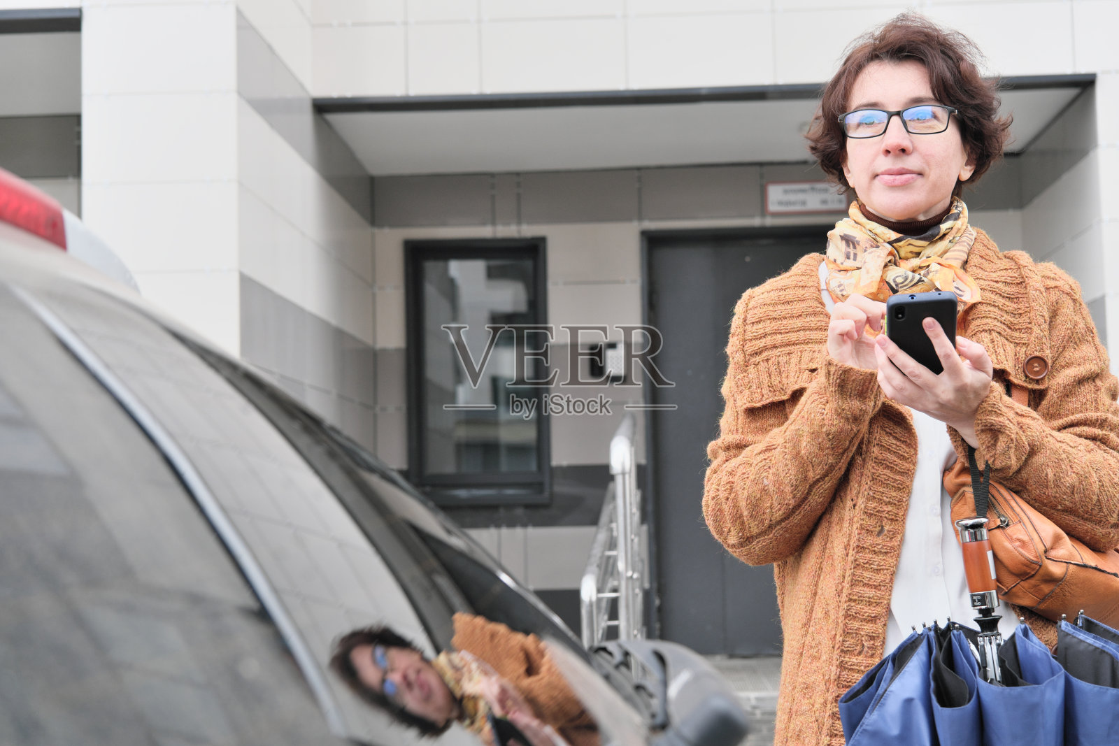 成熟的女人在城市的大街上等车照片摄影图片