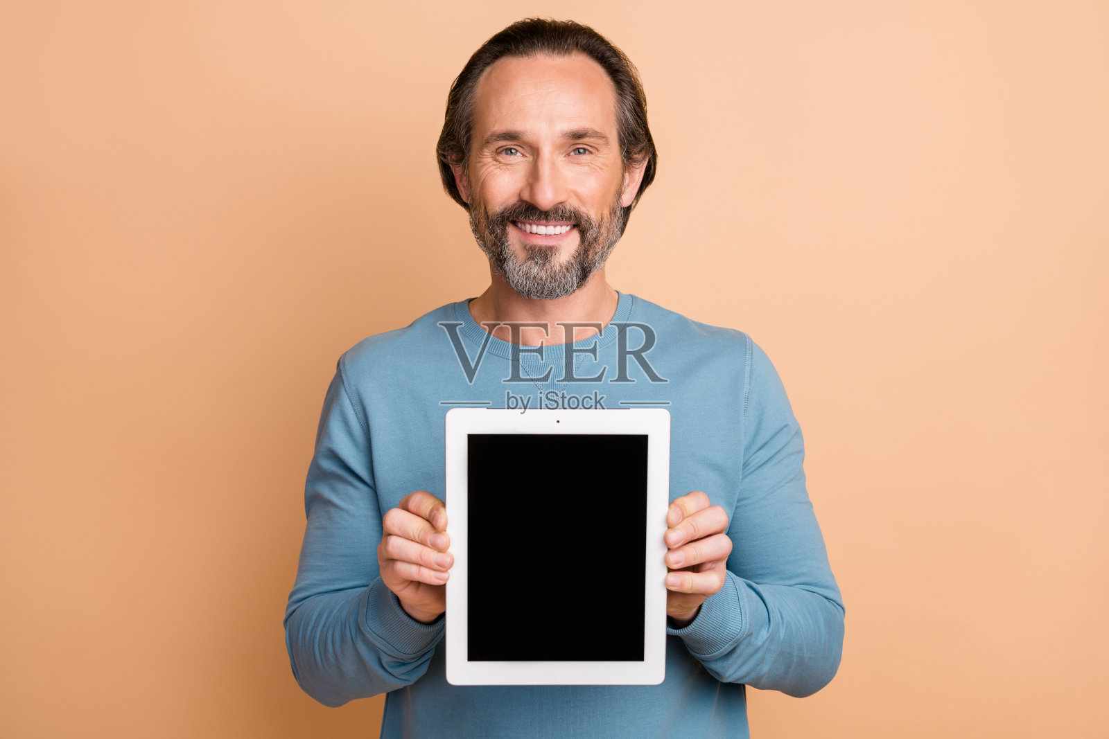 商人的照片肖像显示平板触摸屏与复制空间隔离在柔和的米色背景照片摄影图片