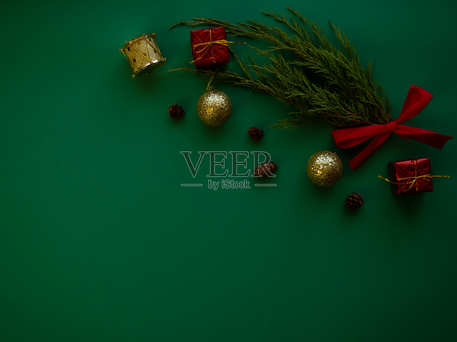 圣诞组成。云杉树枝，礼盒，红色蝴蝶结，圣诞球，糖果，绿色背景上的装饰品。圣诞节、冬天、新年概念。照片摄影图片