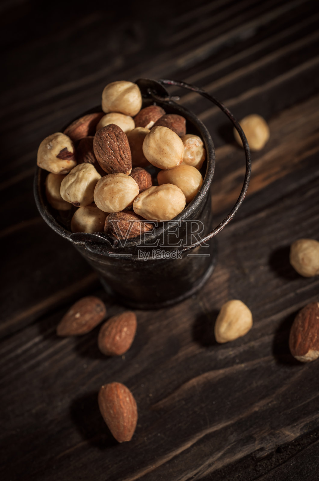 小桶什锦坚果放在木制背景上照片摄影图片