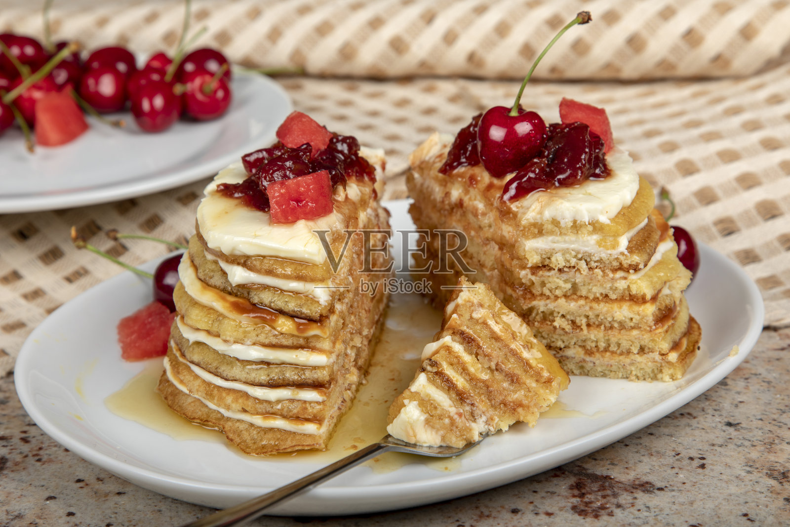 涂上奶油芝士和焦糖酱的层叠薄煎饼。照片摄影图片