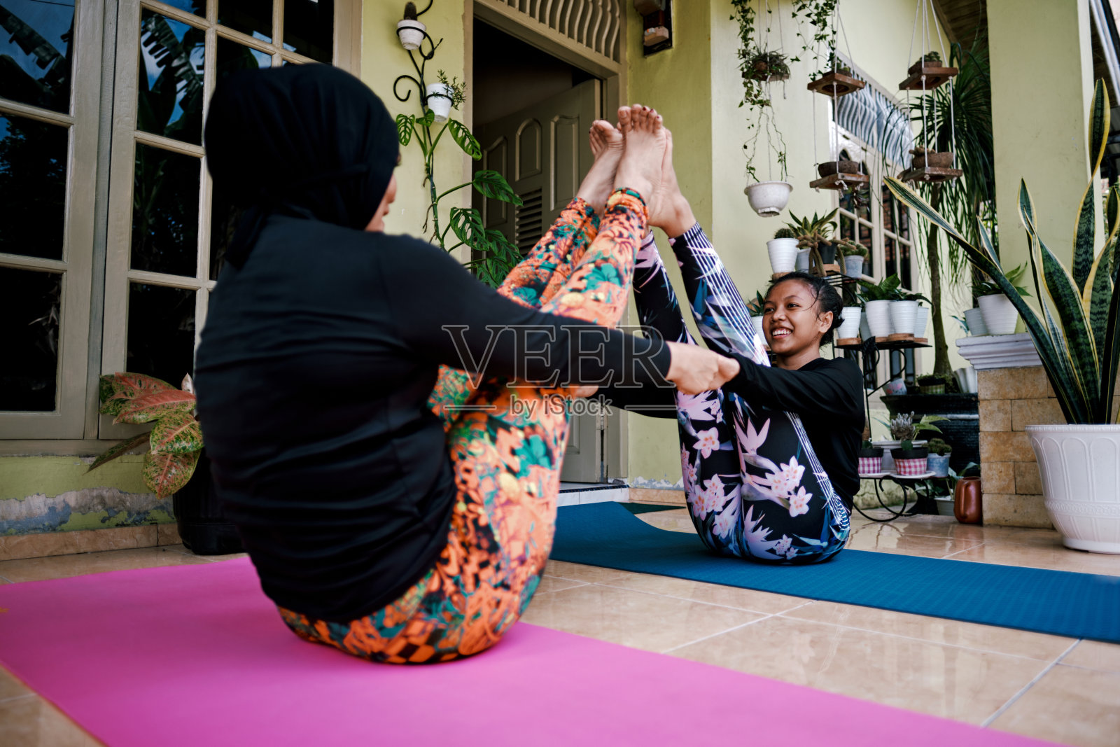 母亲和女儿在家前院做瑜伽照片摄影图片