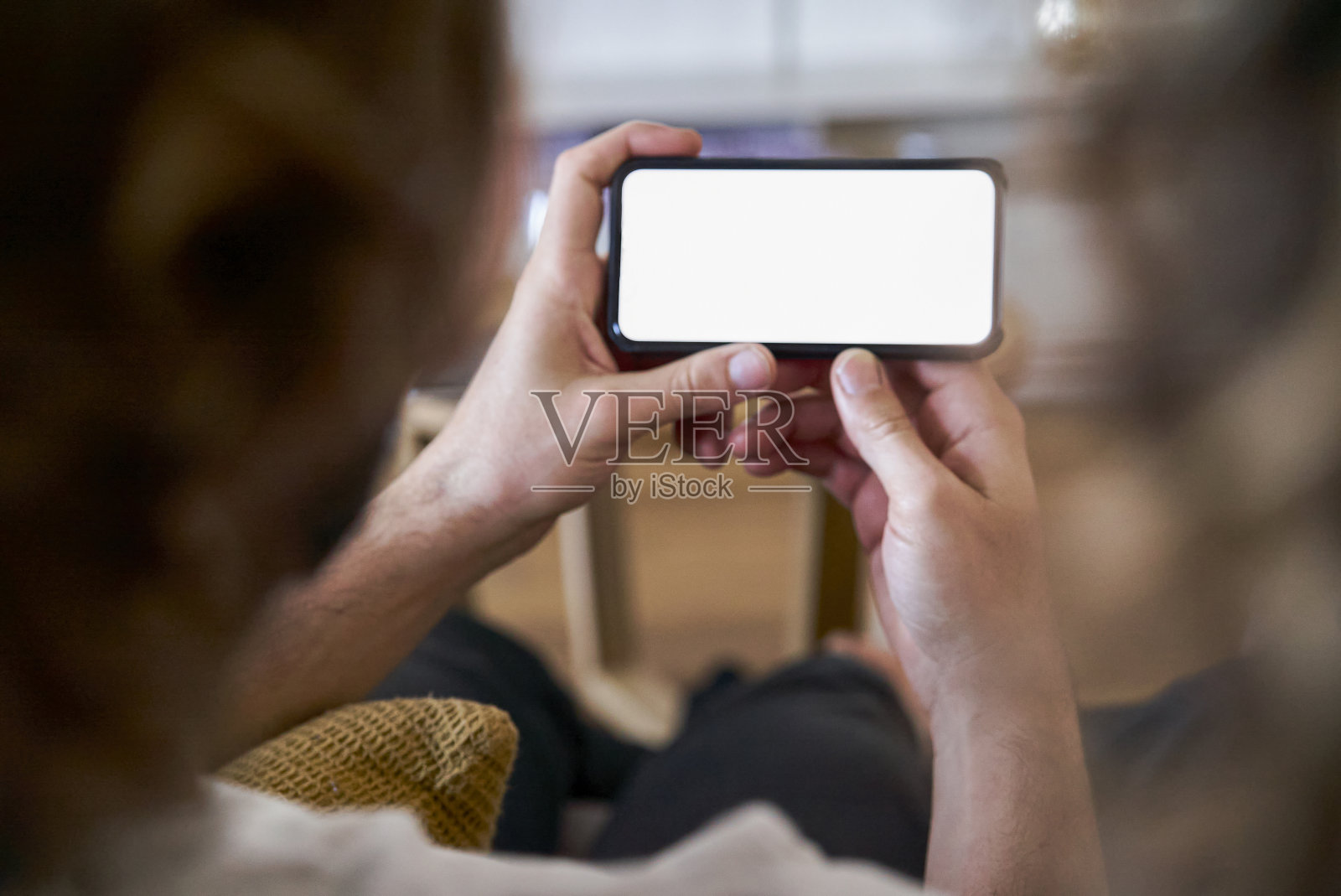 年轻男子的手在家里拿着智能手机照片摄影图片