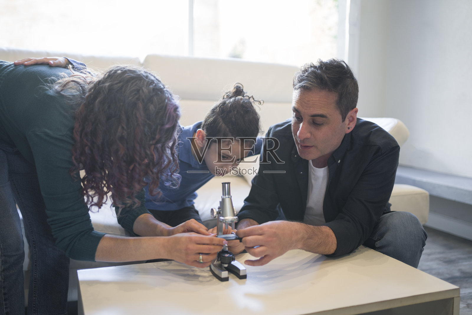 妈妈和爸爸帮助儿子使用显微镜照片摄影图片