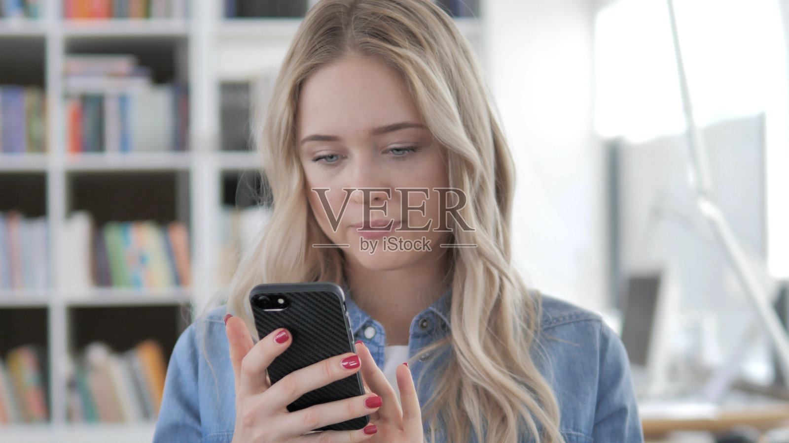 年轻的金发女子在打电话，打字留言照片摄影图片