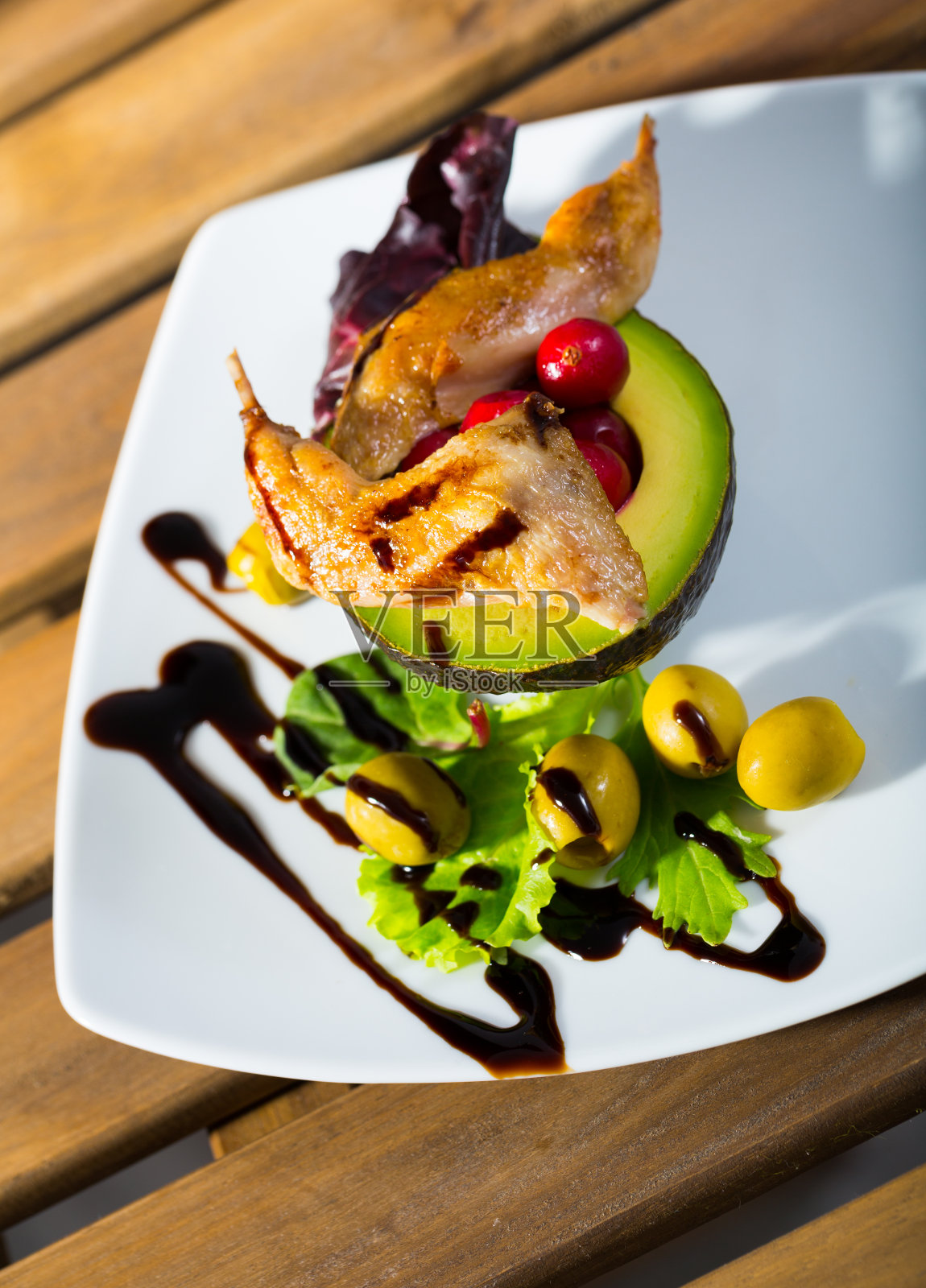 美味的鹌鹑腿与意大利面，鳄梨和绿色蔬菜照片摄影图片