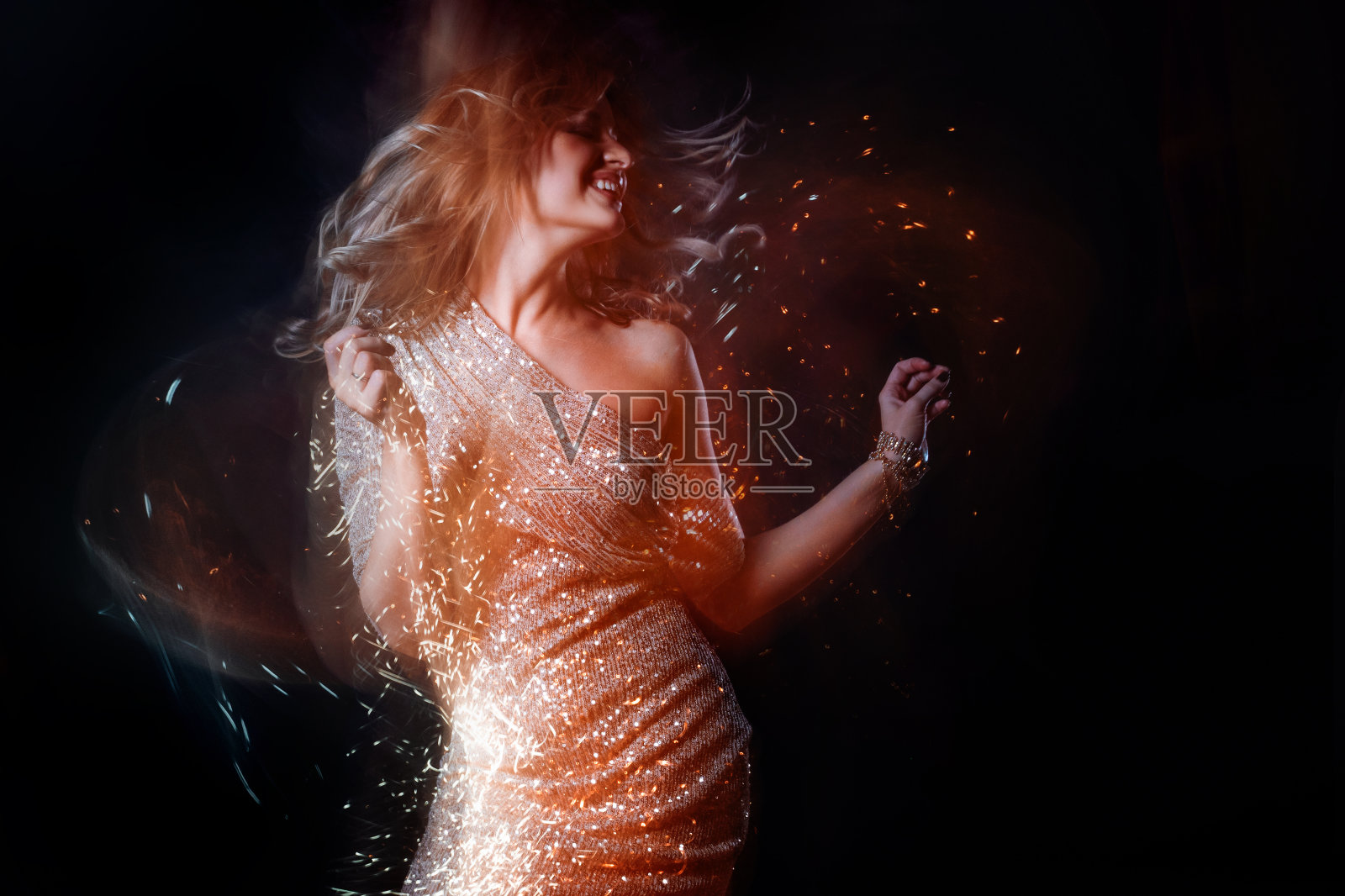 迷人的金发舞女在俱乐部，闪耀的金光，动作效果。照片摄影图片