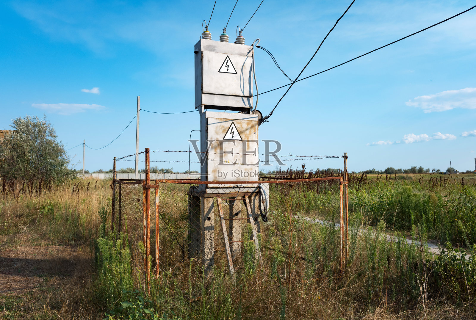 农村地区用铁丝网围起的旧变电站。照片摄影图片