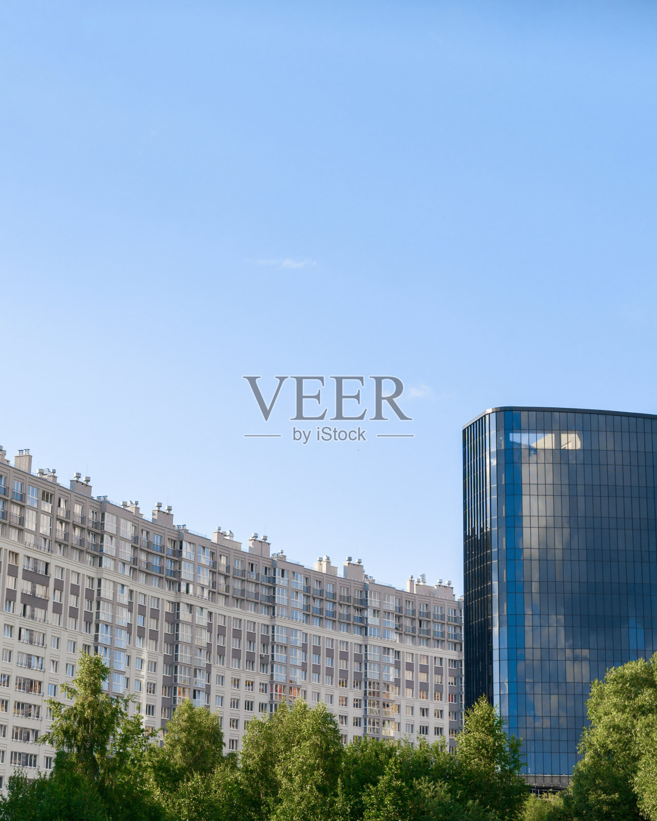 高层建筑有许多窗户，蓝色的天空背景照片摄影图片