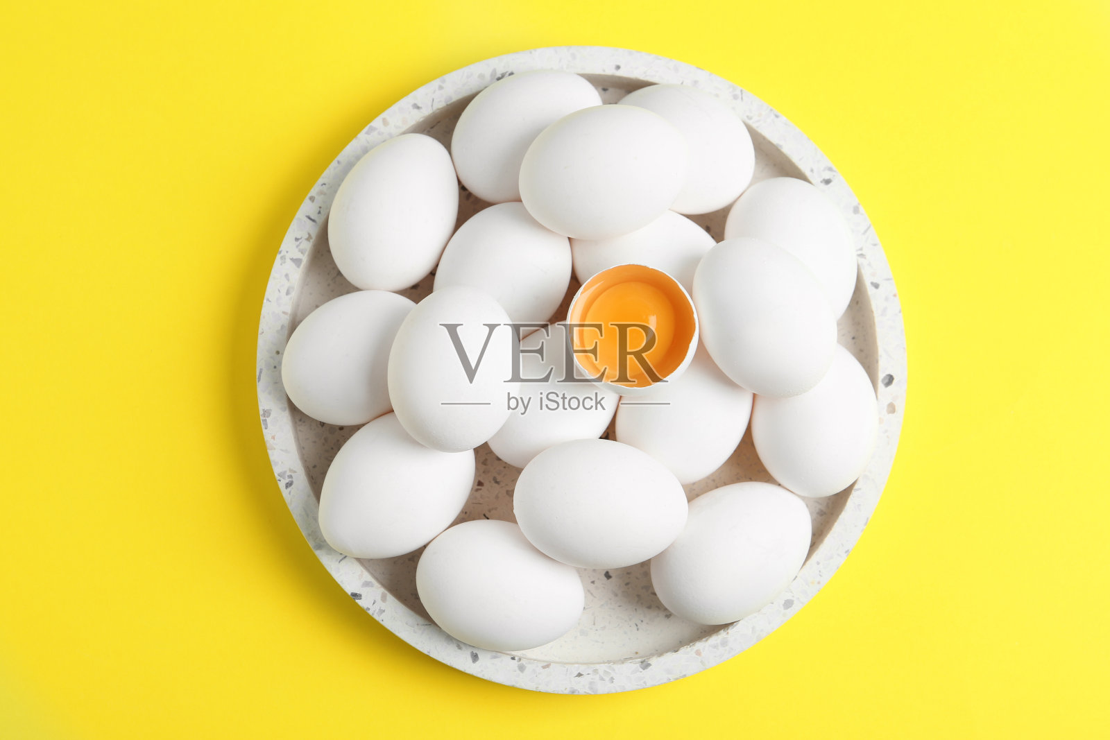 新鲜生鸡蛋黄色背景，俯视图照片摄影图片